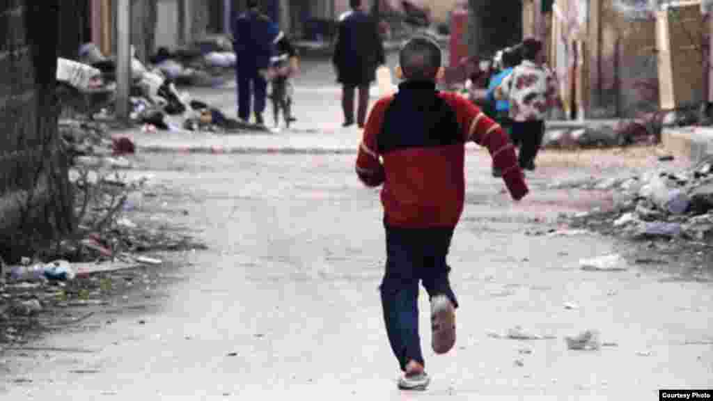 Một bé trai Syria chạy trên đường phố ở thị trấn Bostan Homs Al-Dewan trong thành phố Homs, ngày 26/1/2013.