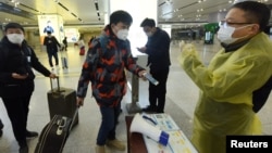 中国浙江省杭州市火车站一名旅客使用手机中的绿色健康码向车站检疫人员显示他的健康状况。(2020年2月17日)