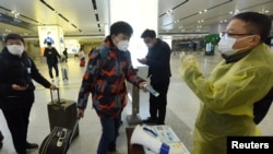 中国浙江省杭州市火车站一名旅客使用手机中的绿色健康码向车站检疫人员显示他的健康状况。(2020年2月17日)