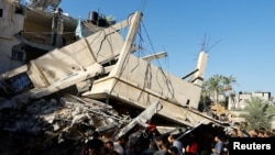 2023年10月21日,加沙地带南部汗尤尼斯,巴勒斯坦人在以色列袭击一处房屋的现场搜寻伤亡人员。(路透社)