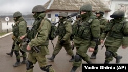 俄罗斯支持的分离武装走过在克里米亚的一座乌克兰军事基地 (资料照)