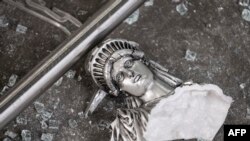 A broken Statue of Liberty figure is seen between glass shatters outside a looted souvenir shop after a night of protests over the death of African-American George Floyd in Minneapolis, in Manhattan in New York City, June 2, 2020.