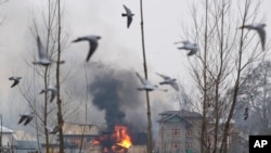 印控克什米尔地区,一处疑似激进分子在枪战中避难的居民楼内冒着滚滚浓烟。(2019年2月18日)