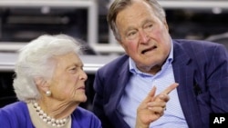 美国前总统老布什和夫人芭芭拉·布什在休斯顿看球赛(2015年3月29日)。