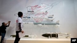 资料照:参观者在北京一次航空展上观看中国航空工业集团展出的导弹和炸弹模型。(2013年9月25日)