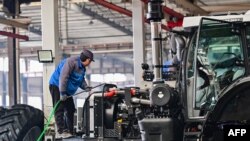 2025年1月27日,一名工人在中国东部山东省青州市的一家拖拉机制造厂的车间组装拖拉机。