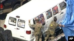 WPLG-TV提供的视频显示联调局特工正把一辆箱型车遮盖起来。 (2018年10月26日)