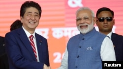 日本首相安倍晋三与印度总理莫迪在艾哈迈德巴德的高铁动工仪式上握手。(2017年9月14日)