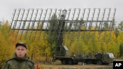 资料照:一名俄罗斯士兵站在位于赤塔市以北约80公里处森林中部署的“天空-M”(Nebo-M)雷达前。 (2018年9月12日)