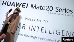 一名模特站在华为在英国伦敦发起的华为Mate20系列的广告牌前。(2018年10月16日)