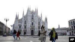 一名戴口罩的妇女走过米兰的大教堂广场