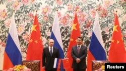 俄罗斯总统普京(左)和中国国家主席习近平2014年11月9日在北京钓鱼台国宾馆举行的签字仪式上。