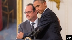 美国总统奥巴马和法国总统奥朗德在白宫的记者会上拥抱(2015年11月24日)