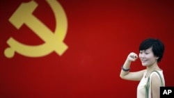 一名女子在中国共产党党旗下做宣誓姿势 (资料照片)