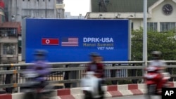 越南民众在观看有关美朝二次峰会的广告招牌和视频(2019年2月21日)