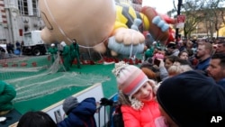 7岁的艾米莉.布朗与父亲在纽约观看参加梅西圣诞节大游行的大气球被充气吹起。(2017年11月23日)