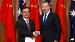 2015年6月17日澳大利亚堪培拉议会大厦: 澳大利亚总理艾伯特(右)与中国商务部长高虎城握手