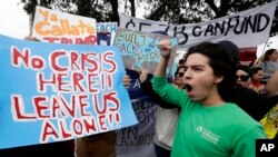 Những người phản đối xây tường biên giới tụ tập trước sân bay quốc tế McAllen tại Texas khi ông Trump đến đây để thị sát biên giới