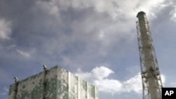 Tokyo Electric Power Co. (TEPCO)'s tsunami-crippled Fukushima Daiichi nuclear power plant No.6 (L) and No.5 reactor buildings are seen from a bus window in Fukushima prefecture, February 20, 2012