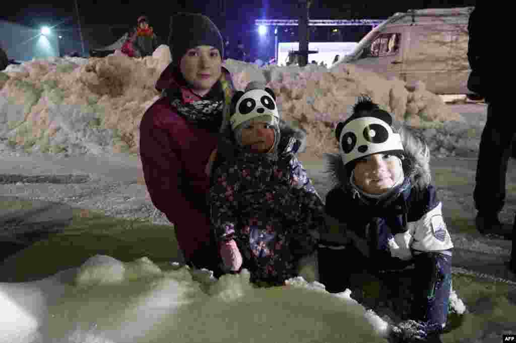 在芬兰市镇艾赫泰里举办的一场嘉年华狂欢会上,儿童戴着熊猫帽子,欢迎两只大熊猫(2018年1月18日)。