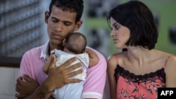 一对夫妇在巴西的医院里抱着他们由于蚊子叮咬而患病的孩子(2016年1月27日)