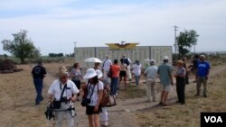 米尼多卡“朝圣者”欣赏着重新创建的荣誉榜,荣誉榜树立在营区入口处,上面列出了在二战期间加入美军的被拘禁者的名字。(美国之音班泽拍摄)