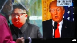 一名男子走过东京街头正在播放美国总统川普(右)和朝鲜领导人金正恩画面的电视屏幕。(2018年3月9日)