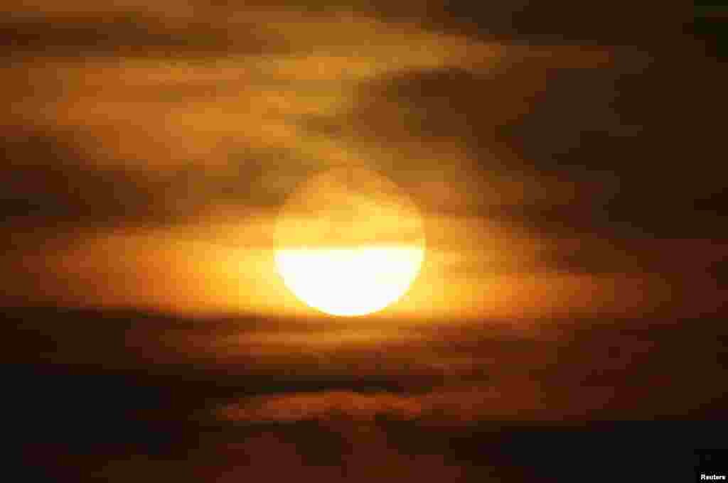 2016年12月16日,雾霾中的北京夕阳。北京市空气重污染应急指挥办公室12月15日发布今年首个空气重污染红色预警。北京周边六个省市共有23个城市将受到此次雾霾天气困扰。