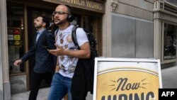 资料照片:人们走过华盛顿的一家在门外摆着招聘告示的餐馆。(2023年10月5日)