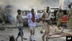 索马里首都摩加迪沙发生爆炸,图为一名军人搀扶一名受伤的平民。(2017年10月14日)