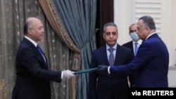 资料照片:伊拉克总统萨利赫向新获任的伊拉克总理卡迪米做指示。(2020年4月9日)