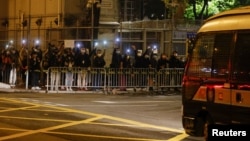 在载有47名香港民主派活动人士的囚车抵达荔枝角收押所时,民主派支持者们高举手机手电声援。(2021年3月4日)