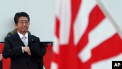 日本首相安倍晋三在日本某基地检阅日本自卫队成员。