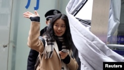 周晓璇在走进北京海淀区一家法院前向支持者招手。(2020年12月2日)