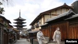 日本京都两名戴着口罩的妇女走过空荡荡的街头。(路透社2021年1月13日)