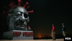 雕塑家陈维明和苏立德站在他们的作品“中共病毒”前(美国之音记者文灏拍摄)