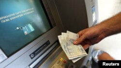 2015年6月30日希腊雅典: 一人从提款机取出60欧元。这是希腊银行实行资本管制之后所允许的最大取款数量