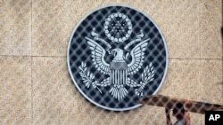 一位男士扛着硬纸板走在美国驻哈瓦那使馆院内。(2017年9月29日)