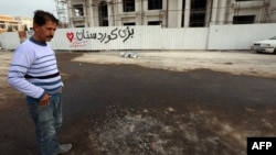 资料照片:伊拉克库尔德斯坦地区首府埃尔比勒2月15日遭到火箭袭击后的第二天,一位男子站在现场。作为对火箭袭击的回应,美军2月25日空袭了叙利亚东部伊朗支持的激进组织的设施。