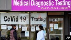 资料照片:伊利诺伊州一家实验室的工作人员排队接受新冠病毒检测(2020年10月21日)
