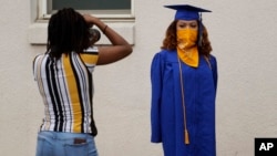 2020年5月5日德克萨斯州奥斯汀市安德森高中高一位中生穿着礼袍,戴着口罩拍照