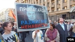 去年秋季莫斯科的一场主张和平反战大游行中,示威者手举基谢廖夫画像,上面写着“宣传煽动仇恨”,抗议官方媒体谎言宣传。