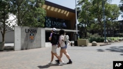 资料照:两位学生走向澳大利亚悉尼的新南威尔士大学。(美联社提供)