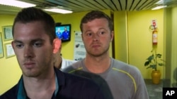 美国奥运游泳选手本茨(左)和康杰尔(右)离开里约国际机场的警察局