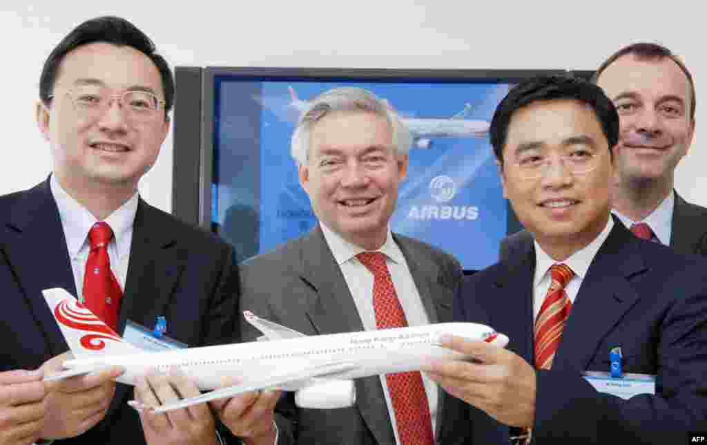 2007年6月21日,海航集团的子公司香港航空公司的董事长任卫东(音译)和王健(右起第二人)与空中客车公司的销售总监John Leahy在巴黎国际航空展期间签订合同之后合影。香港航空公司同意以目录价格从空客购买51架飞机,价值55亿美元(41亿欧元)。