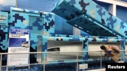 一名参观者在广东珠海航空展上观看新型地对舰CM-401导弹系统。(2018年11月8日)