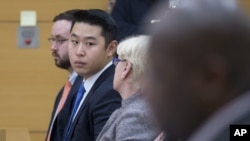 纽约市警察梁彼得(左起第二人)及其律师小组在布鲁克林高级法院(2016年2月11日)