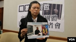 李明哲的妻子李净瑜2017年3月向媒体展示李明哲以往活动的照片 (资料照片)
