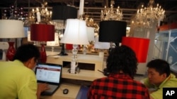 图为着名购物网站“淘宝”的员工检验公司网页资料照