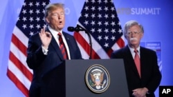 2018年7月12日特朗普(左)和博尔顿在比利时布鲁塞尔北约总部举行的国家元首和政府首脑峰会之后的新闻发布会上